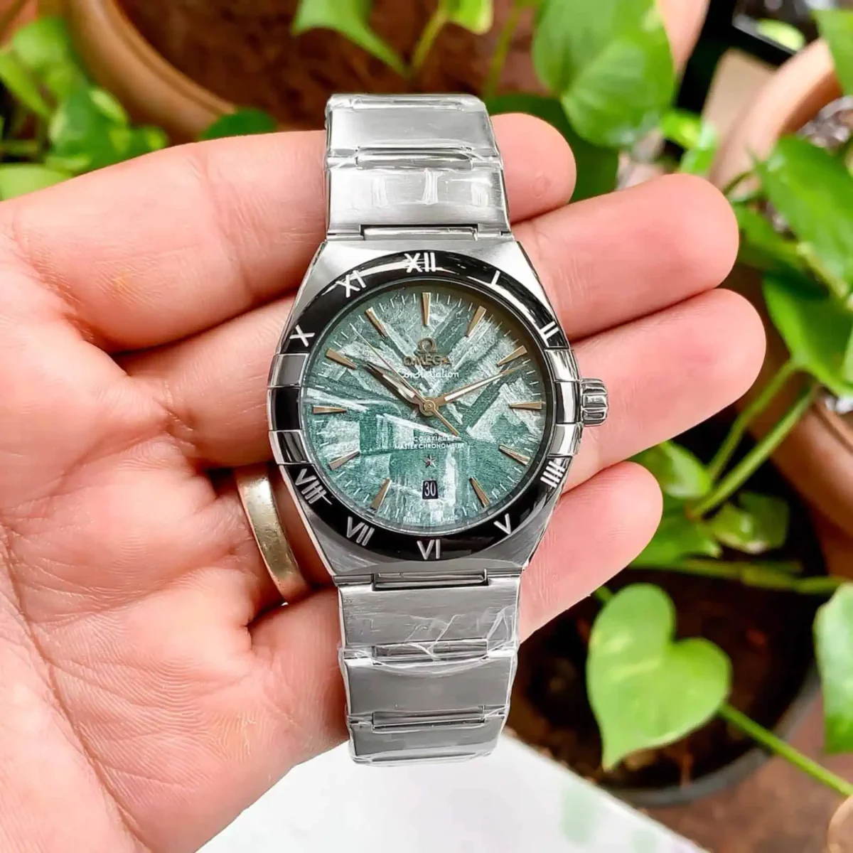 Omega Constellation Meteorite Dial Watch – 41mm Green Dial with Black Bezel – Automatic macro shot with man holding in hands