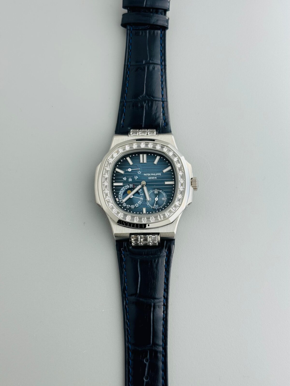 Patek Philippe Nautilus 5712 Silver Blue Dial Men’s Watch featuring 24-hour time, date indicator, sapphire crystal, stainless steel case, and automatic movement with open-back design.