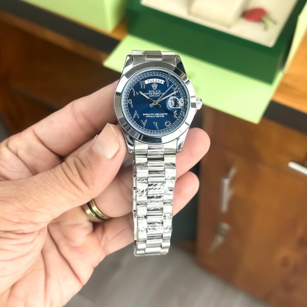 Rolex Day-Date with silver bracelet, Arabic blue dial, and day-date display.